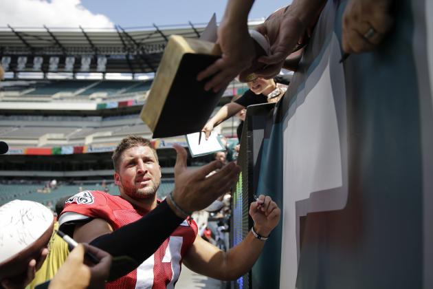 fans hands bible to Eagles line backerTim Tebow
