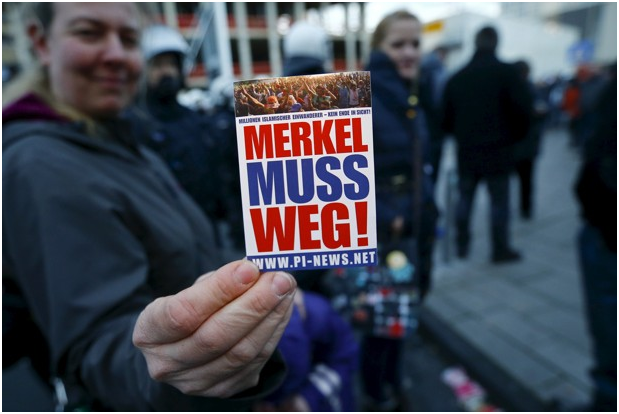 merkel protester with card